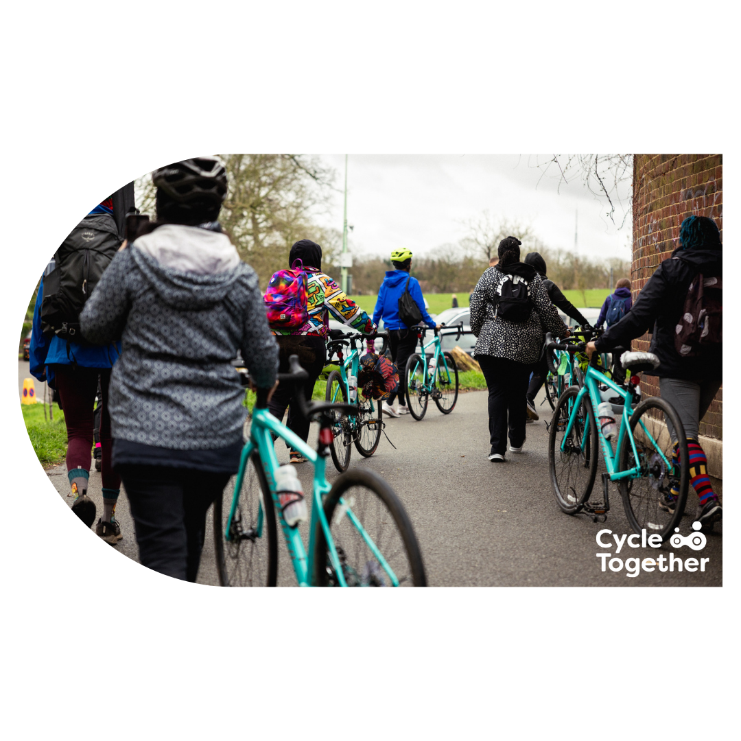 Women walking with bikes after a cycling session Women walking with bikes after a cycling session